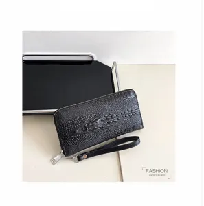 Portefeuille long en cuir noir motif crocodile avec dragonne et fermeture éclair.