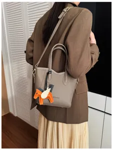 Borsa a secchiello minimalista in stile coreano chic con ciondolo ad ala per donna.
