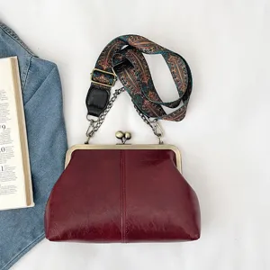 Vintage kiss-lock shoulder bag for women, dark red PU leather handbag with wide strap.
