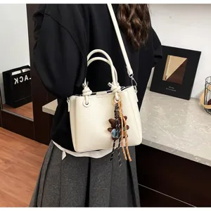 Korean style soft leather bucket shoulder bag with cute bear pendant for women daily commute.