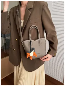 Vista dettagliata della chic borsa a secchiello coreana con ciondolo a forma di cavallo alato.