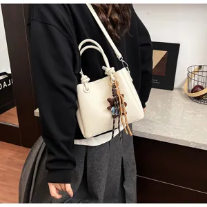 Stylish Korean soft leather bucket bag for women featuring a cute bear pendant charm.