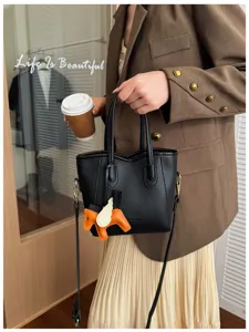 Vista dettagliata della borsa a secchiello in pelle nera stile coreano con manici chic.