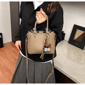 Chic khaki faux leather bucket bag with cute bear pendant and shoulder strap for women.