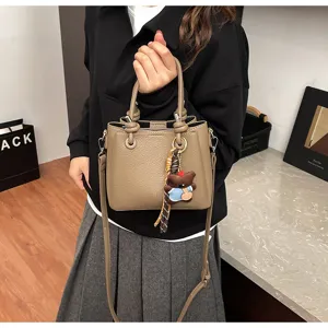Stylish soft leather bucket bag with cute bear pendant, versatile women shoulder bag.