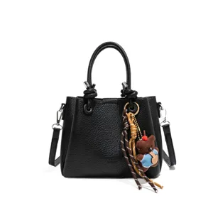 Black leather bucket bag for women with cute bear charm, stylish casual shoulder handbag.