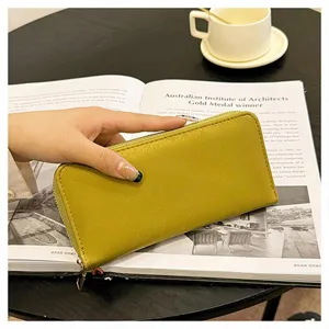 Dettaglio di un elegante portafoglio lungo giallo con zip, capiente e con scomparti per carte.