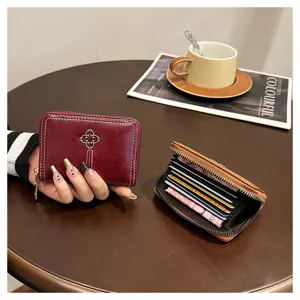 Primo piano del mini portafoglio con cerniera, scomparti per carte e pelle morbida.