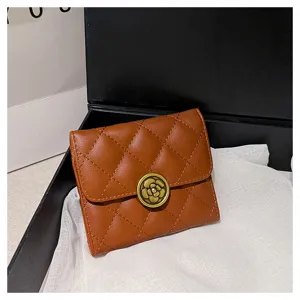 Vue détaillée d'un portefeuille matelassé marron avec fermoir fleur de camélia et motif losanges.