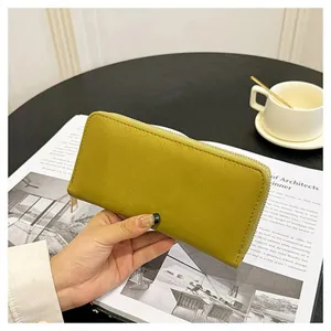 Vista dettagliata di un portafoglio lungo da donna tinta unita con zip e pelle liscia.