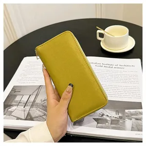 Vista di dettaglio di un elegante portafoglio lungo giallo da donna con zip e scomparti.