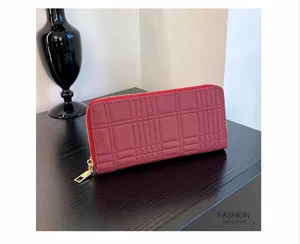 Detailed close-up of red quilted zip-around long wallet with card slots and golden zipper.
