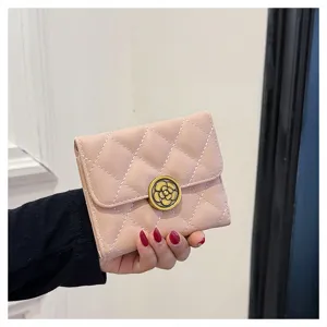 Vue détaillée du petit portefeuille rose matelassé avec fermoir fleur de camélia.