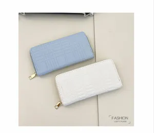 Detailed view of women's long quilted zip wallet with embossed grid pattern and metal hardware.