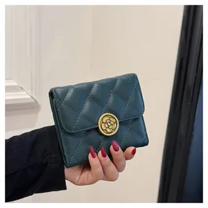 Vue détaillée du portefeuille court matelassé vert foncé avec un fermoir floral vintage.