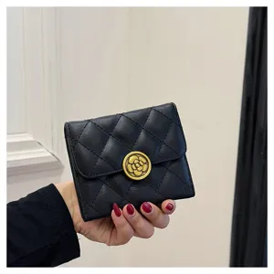 Gros plan sur le portefeuille court matelassé noir avec fermoir élégant fleur de camélia doré.
