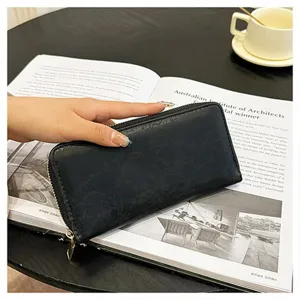 Portafoglio lungo nero con zip da donna, dotato di chiusura lampo sicura e motivo testurizzato.