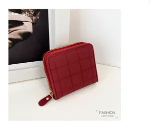 Portefeuille court matelassé rouge zippé, design minimaliste élégant avec détails métalliques.