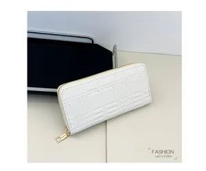 Detail view of a white quilted long zip wallet with multiple card slots and gold hardware.