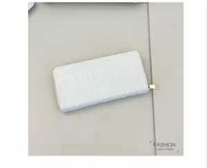 Detail view of white quilted long zipper wallet showing grid texture and gold hardware.