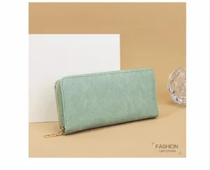Cartera larga verde menta con cremallera, ranuras para tarjetas y detalles dorados en detalle
