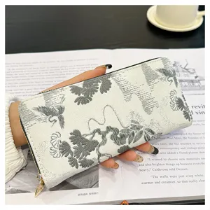 Vue rapprochée détaillée du portefeuille long zippé pour femme avec motif de grue.