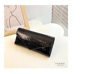 Detailaufnahme der langen Damen Brieftasche mit Kroko Muster und elegantem Dreieck Überschlag.