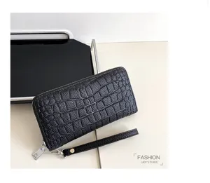 Portefeuille long noir motif crocodile avec dragonne pochette zippée élégante pour femme.