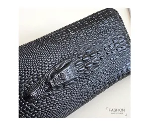 Vue rapprochée de la texture du portefeuille motif crocodile noir avec design de tête en relief.