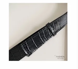 Schwarzer Kroko-Prägung Leder Tasche Riemen Detail zeigt Textur und feine Handwerkskunst.