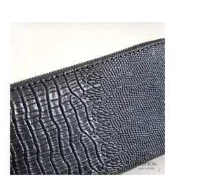 Détail de texture de portefeuille long homme en cuir gaufré avec finition de qualité.