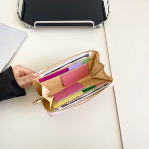 Ροζ καπιτονέ γυναικείο πορτοφόλι με φερμουάρ, θήκες καρτών και χώρους για χαρτονομίσματα.