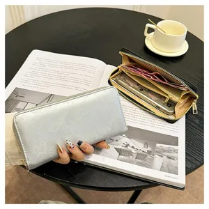 Primo piano di un portafoglio lungo da donna con scomparti per carte e grande capacità.