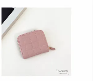 Gros plan sur le mini portefeuille rose matelassé avec de belles coutures et une fermeture éclair.