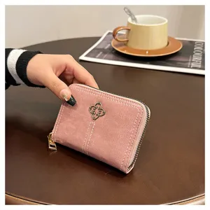 Mini portafoglio rosa con cerniera da donna con ciondolo a trifoglio in metallo e pelle.