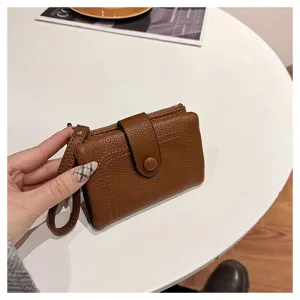 Κομψό καφέ κοντό δερμάτινο πορτοφόλι με λουράκι καρπού και πολλές θήκες για κάρτες.