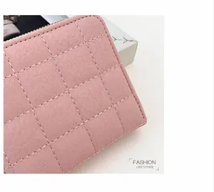 Gros plan sur le portefeuille court matelassé rose avec fermeture éclair et coutures soignées.