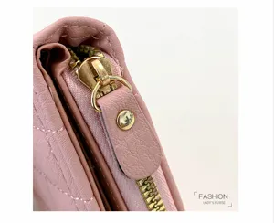 Détail de petit portefeuille matelassé rose avec fermeture éclair dorée et belles coutures.