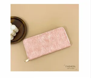 Primer plano detallado del monedero largo rosa texturizado vintage con cremallera dorada.