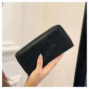Portafoglio lungo nero da donna con chiusura zip, motivo floreale impresso e porta carte.