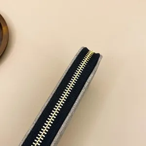 Monedero de mujer estilo retro primer plano con cremallera metálica y lona elegante.