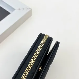 Portefeuille court noir pour femme avec fermeture éclair dorée accessoire de mode.