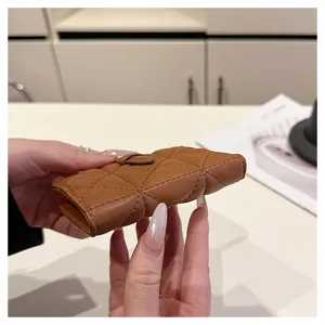 Primo piano del portafoglio corto in PU trapuntato marrone che mostra la sua consistenza.