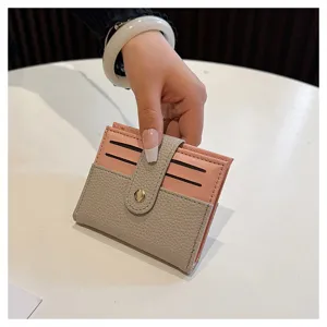 Dettaglio del mini porta carte con design bicolore rosa e grigio e pratici scomparti per carte.