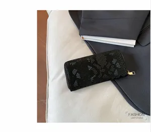 Black snake print long wallet detail showing texture, golden zipper and sleek design for women