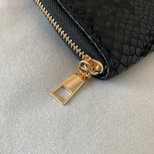 Black snake pattern women's long wallet with golden zipper detail, elegant clutch purse main.