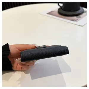 Mini porta carte in pelle nera da donna, elegante piccolo portafoglio sottile dettaglio.