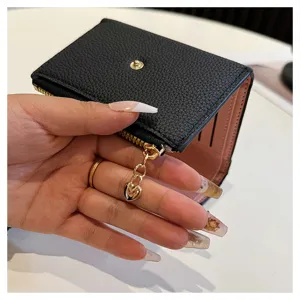 Vue détaillée d'un petit portefeuille noir en cuir PU, intérieur rose, charmant cœur, format compact.