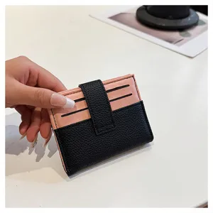 Dettaglio porta carte minimalista da donna, portafoglio in ecopelle rosa e nera con slot.