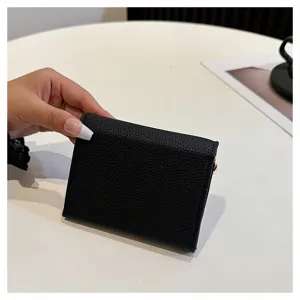 Gros plan d'un petit portefeuille court en cuir PU noir tenu en main, belle texture.